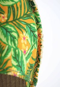 Espadrille avec un tissu coloré représentant des feuilles tropicales et des fleurs ; teintes jaunes et vertes ; semelle en jute ; détails de bordure cousue.