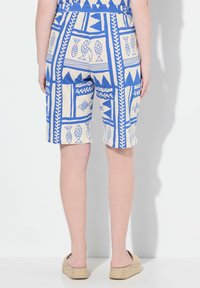Pantaloni corti blu e crema con motivi a pesci e foglie, caratterizzati da una vita elasticizzata e una vestibilità comoda, realizzati in tessuto leggero.