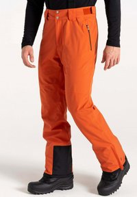 Orange wasserdichte Skihosen mit schwarzen Akzenten an den unteren Beinen, verstellbarem Bund mit Knöpfen, seitlichem Reißverschlussfach und verstärkten Säumen.