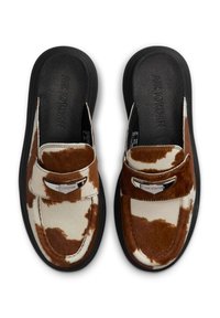 Brune og hvide cowhide-mønstret Air Jordan slip-on loafers med sorte såler og metalliske logodetaljer på toppen.