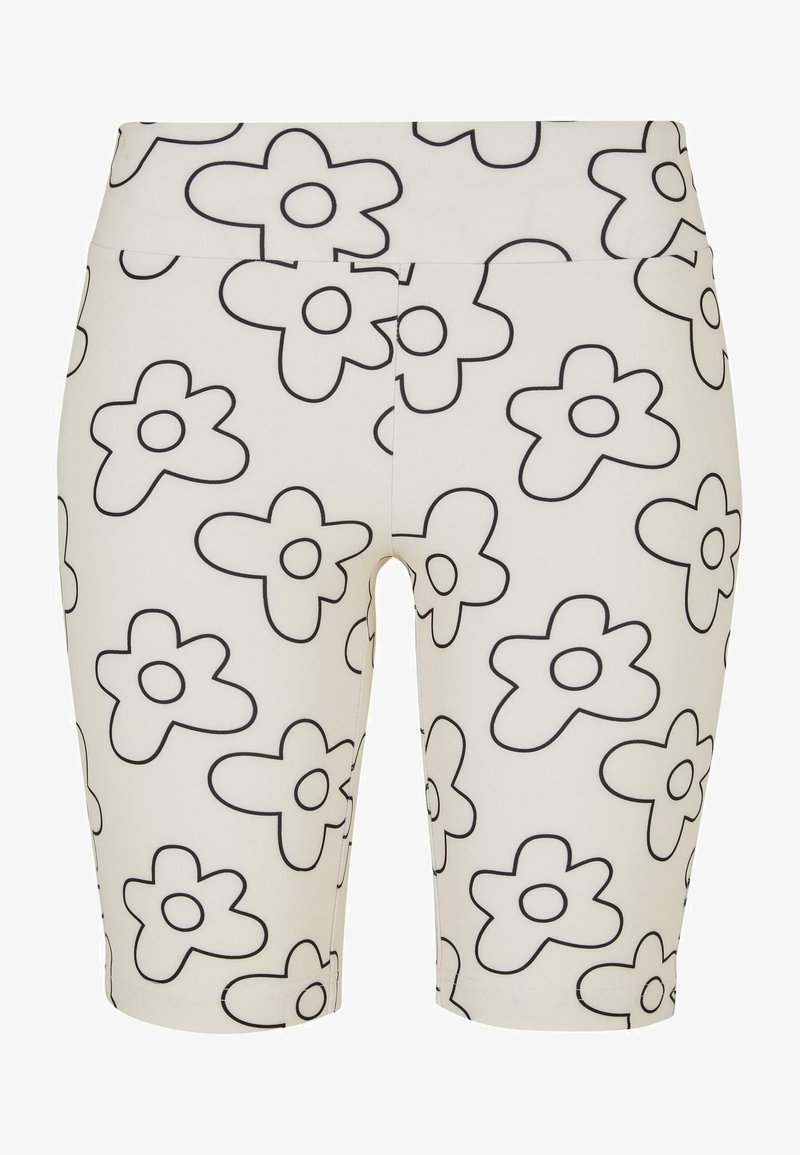Pantalones cortos de bicicleta blancos con grandes patrones de flores negras. Presentan una cinturilla ancha y una textura suave. Estilo hasta la rodilla.