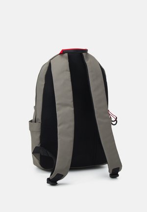 Grey and black backpack with padded straps, mesh back panel, and red top handle, shown from the back on a white background.