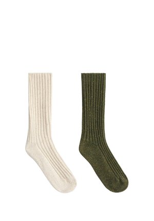 Une chaussette beige et une chaussette vert olive en maille côtelée présentées côte à côte sur un fond blanc.