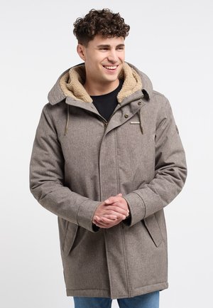 Brown textured coat with a fur-lined hood, buttoned front, and two side pockets. Model wears a black shirt underneath.