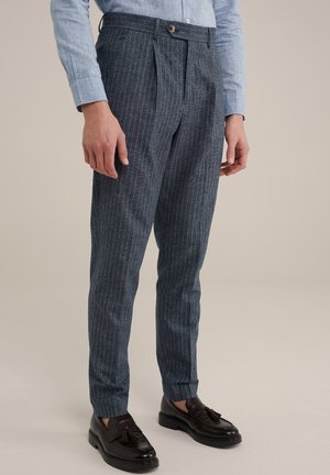 Pantaloni in tessuto blu scuro con righe bianche verticali, caratterizzati da un frontale piatto, tasche laterali e chiusura con bottone. Completati con una vestibilità sartoriale.