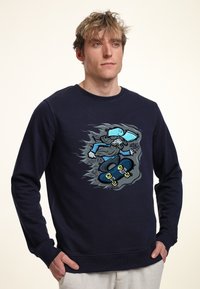 Sweatshirt blu navy con una grafica di uno skateboarder in movimento, con illustrazioni dettagliate e accenti in grigio e blu chiaro.