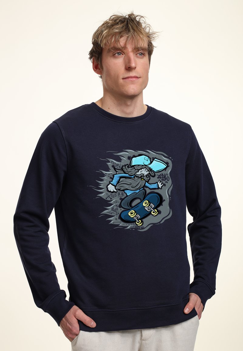 Sweatshirt blu navy con una grafica di uno skateboarder in movimento, con illustrazioni dettagliate e accenti in grigio e blu chiaro.