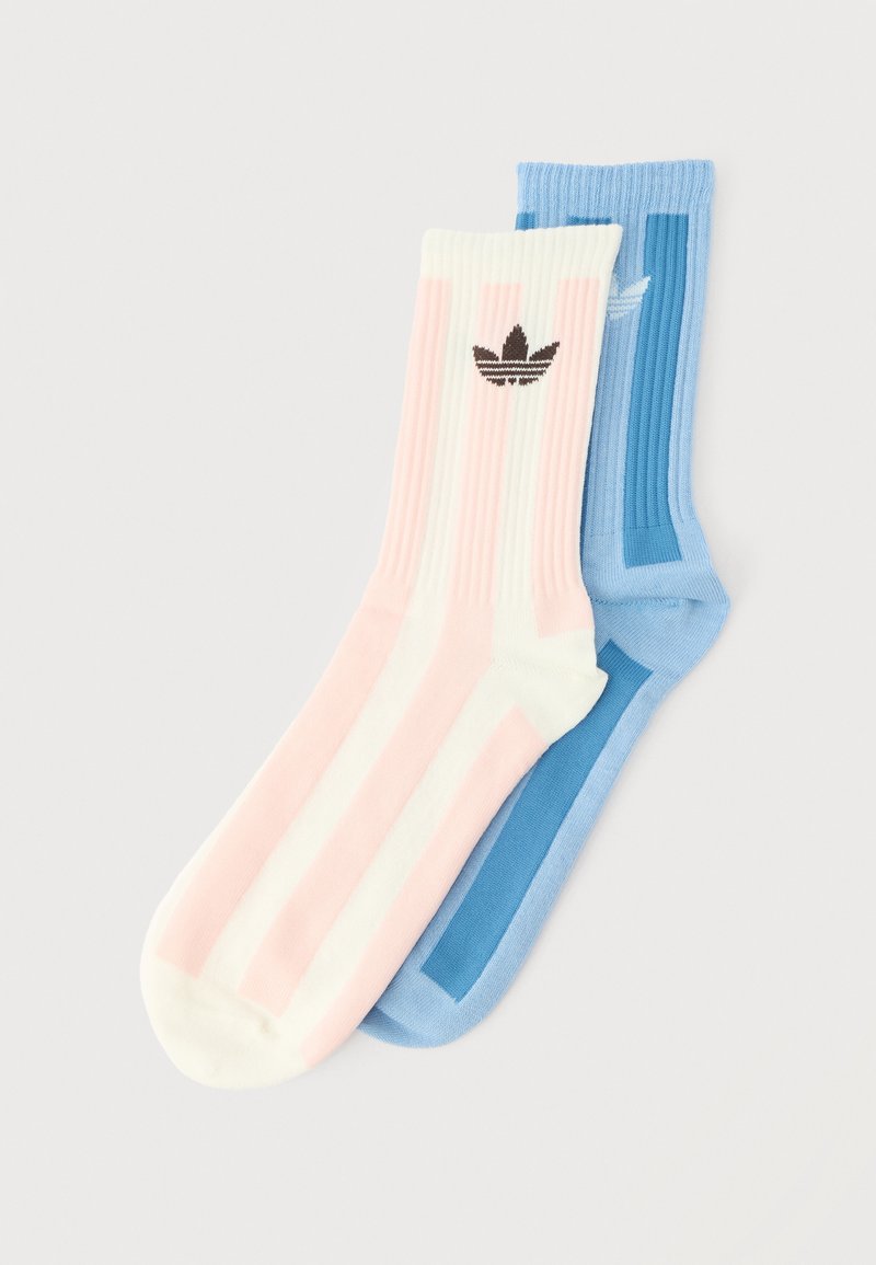 To par ribstrikkede ankelsokker, den ene i pink og hvide striber med et sort logo, den anden i ensfarvet blå med mørkeblå detaljer.