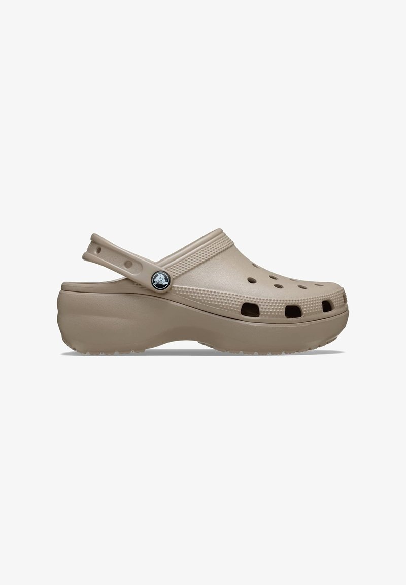Sabot beige en plastique léger et résistant. Doté de trous de ventilation, d'une sangle arrière surélevée et d'une semelle texturée pour une meilleure adhérence.