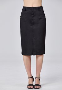 Jupe crayon noire en tissu lisse, dotée d'une taille ajustée, d'une couture avant et de deux poches latérales décoratives avec des accents dorés.