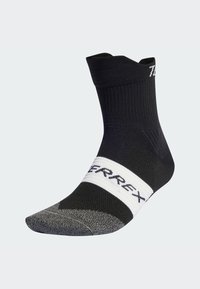 Calcetín deportivo negro con parte superior acanalada, banda blanca con el logotipo "TERREX", puntera reforzada y acento gris en la puntera. Largo hasta la mitad de la pantorrilla.
