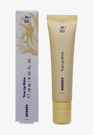 Korres True Lip Shine in a beige tube with a ribbed yellow cap, 10 mL. Box features minimalist design with gold accents and product details.