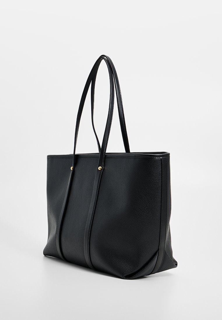 Schwarze strukturierte Leder-Tote-Tasche mit langen doppelten Griffen und Akzenten aus goldenem Nieten, vor einem schlichten hellen Hintergrund präsentiert.