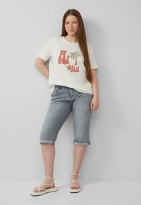Witte t-shirt met een rood en groen palmgraphic, gecombineerd met grijze denim shorts met opgerolde mouwen en beige sandaaltjes met bandjes. Soepele stof, casual pasvorm.
