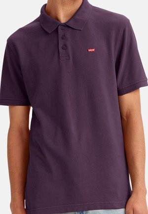 Camisa polo morada de algodón con cuello, tres botones y un pequeño logo rojo de Levi's en el lado izquierdo del pecho. Corte casual.