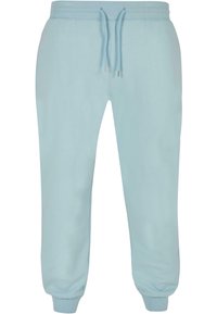 Lyseblå joggebukser laget av mykt stoff, med elastisk liv og snor, og smale mansjetter ved anklene.