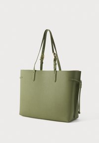 Žalios tekstūruotos odos totalinė rankinė su dviem rankenomis, paprastu dizainu ir kutų detalėmis šonuose. Puošta auksinės spalvos metalinėmis detalėmis.