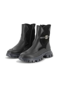 Botines negros hechos de cuero y ante, con una suela de goma gruesa, cremallera lateral y un acento metálico con el nombre de la marca.