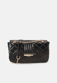 Black quilted handbag with a glossy finish, gold chain strap, and a rectangular body. Features a logo plaque and vertical stripes on one side.