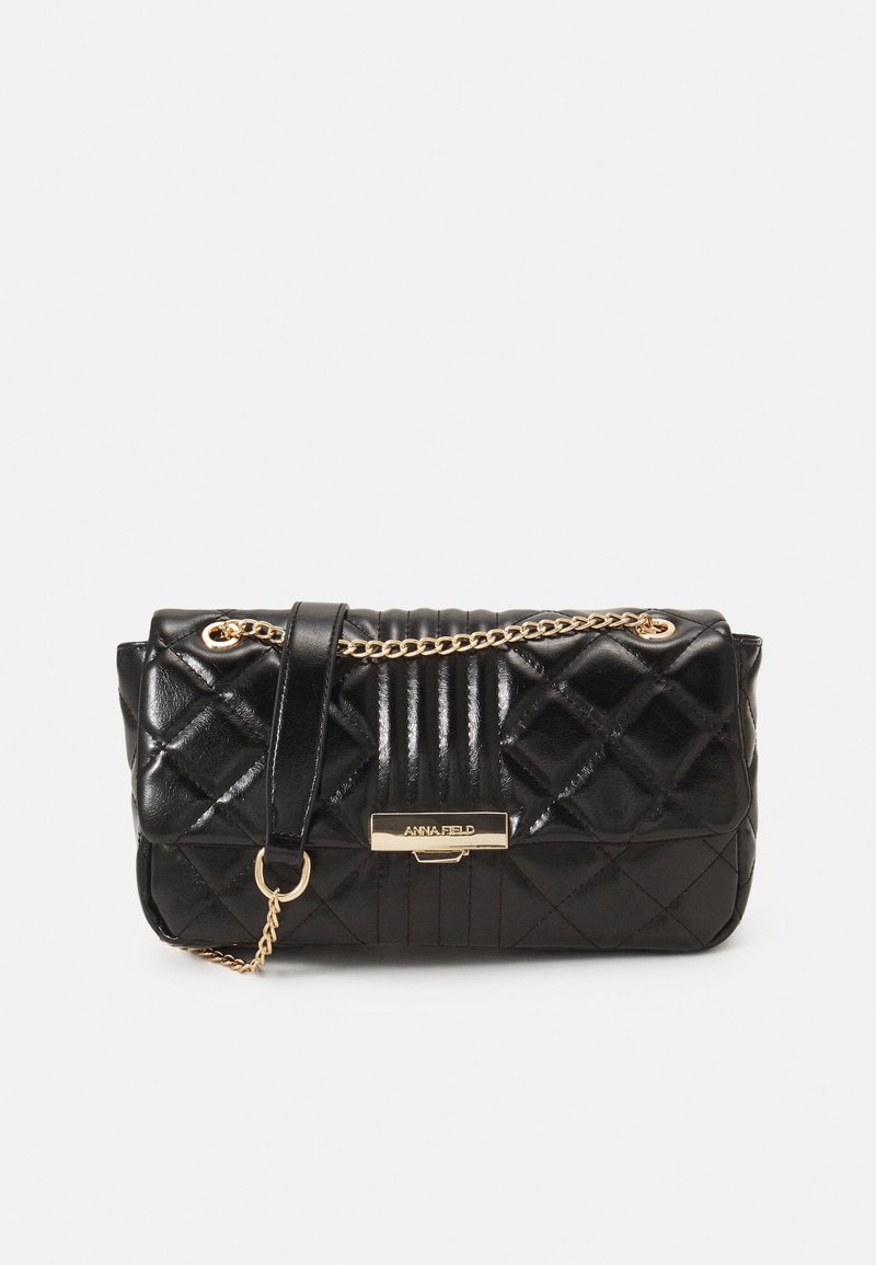 Black quilted handbag with a glossy finish, gold chain strap, and a rectangular body. Features a logo plaque and vertical stripes on one side.
