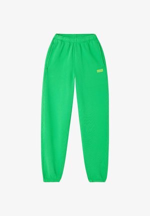 Pantaloni della tuta di un verde brillante con fascia elastica in vita e ai polsi, tasche laterali e piccolo logo "American Vintage" sulla parte superiore della coscia sinistra.