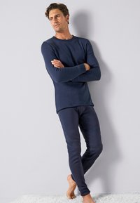 Maglia termica e leggings in misto cotone, design aderente, maniche lunghe, scollatura rotonda, texture liscia, confortevoli per il freddo.