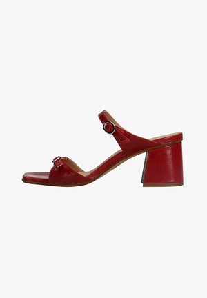 Red leather block-heeled sandal with an open toe and adjustable strap featuring a metal buckle accent. Flat sole with textured finish.