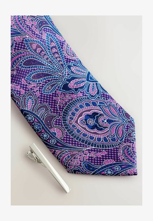 Lilla ja sinine paisley lips, mis on kaunistatud keerukate lillemustritega, koos hõbedase lipsuklambriga, mis on kõrvale asetatud. Sile tekstuur ja erksad värvid.