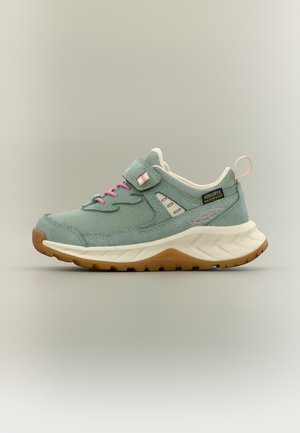 Jasnozielony wodoodporny sneaker z różowymi sznurowadłami, beżową podeszwą środkową, brązową podeszwą zewnętrzną i paskiem na rzep na neutralnym tle.