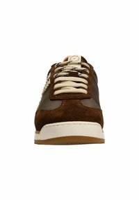 Brown sneaker featuring a leather and suede upper, beige laces, and a white rubber sole. Notable logo on tongue.