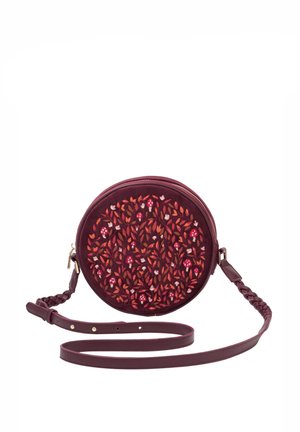 Sac bandoulière rond couleur bordeaux avec sangle tressée et broderie de feuilles rouges et orange ainsi que des champignons au chapeau rouge sur le devant.