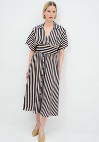 Vestido midi a rayas en azul marino y beige, con cuello, mangas cortas, corte relajado, cinturilla elástica y cierre de botones en la parte frontal. Textura de tela suave.