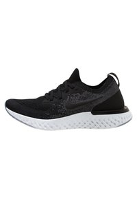 Zapatilla deportiva negra con parte superior de punto y detalles texturizados, que presenta una entresuela blanca y acentos negros. Diseño ligero y transpirable.