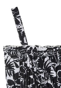 Tessuto a motivo bianco e nero con foglie tropicali, con una parte superiore arricciata in elastico e spalline regolabili. Texture liscia, design leggero.