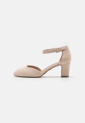 Pantof cu toc înalt din suede bej, cu curea la gleznă, vârf rotund, toc chunky de 4 cm și linii curate; textură netedă cu detalii de cataramă ajustabilă.