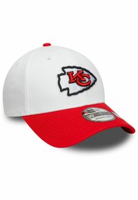 Gorra blanca con visera roja, con el logotipo bordado "KC" en un contorno negro. La etiqueta de tamaño indica "39THIRTY, Mediano-Grande."