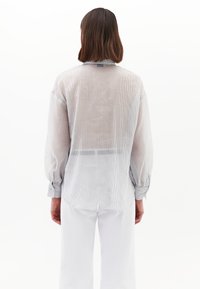 Gestreiftes Langarmhemd aus leichtem Stoff mit halbtransparenter Textur, Stehkragen und geknöpften Manschetten, von hinten betrachtet.