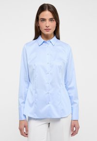 Light blue long-sleeve shirt with a classic collar, front button closure, and tailored fit. Smooth texture with subtle seams.