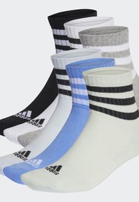 Cinco pares de calcetines con estampados coloridos. Los materiales incluyen algodón y poliéster. Colores: negro, gris, blanco, azul y verde claro.