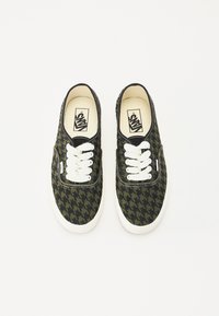 Platnene tenisice u crno-zelenoj bojama s uzorkom houndstooth, s bijelim vezicama i gumenim potplatima; Vans logo na ulošku.