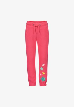 Pantalon de jogging rose avec taille à cordon, présentant des motifs d'étoiles de différentes couleurs et textures sur la jambe gauche. Poignets élastiqués.