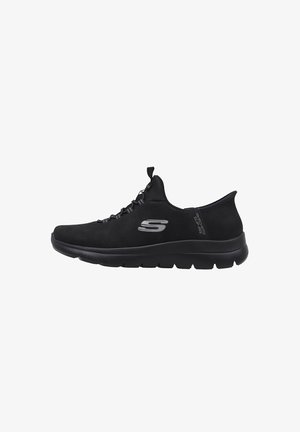 Zapatilla deportiva negra con parte superior de tela suave, diseño de cordones, suela acolchada y un logotipo lateral, que presenta una forma elegante y minimalista.