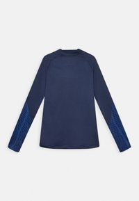 Tumman sininen pitkähihainen paita, jossa on kuviollista tummansinisistä geometrisia muotoja alaosassa, esitetty tasaisesti valkoisella taustalla.