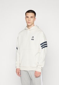 Cremefarvet hættetrøje med marineblå striber på ærmerne, med en kængurulomme og broderede Adidas- og Star Wars-logoer.