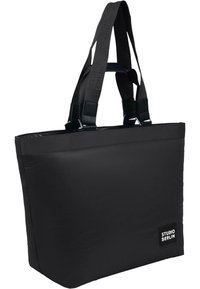 Borsa a mano nera realizzata in tessuto resistente, con manici corti accentuati, forma rettangolare e etichetta logo su un lato.