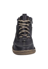 Bottines en cuir noir à lacets beige, avec des détails de couture, un col rembourré et une semelle en caoutchouc, dotées d'une fermeture éclair latérale pour un enfilage facile.