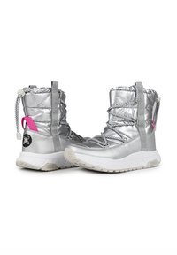 Botas de tobillo plateadas aisladas con cordones elásticos, un acabado texturizado y acento rosa en contraste. Cuentan con una tira de agarre y una suela acolchada.