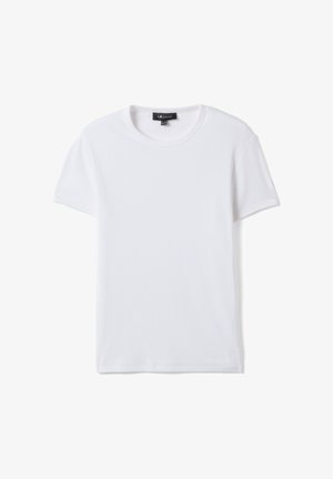 Maglietta bianca semplice a maniche corte con scollo a girocollo e trama a costine, mostrata stesa con un'etichetta del marchio nera visibile sul collo.