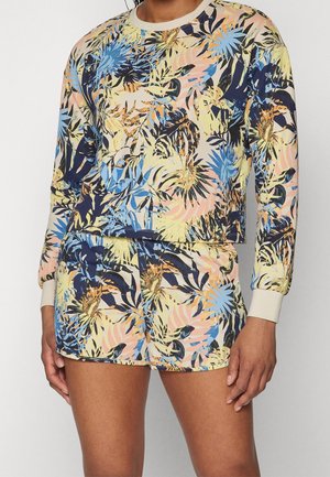 Sæt med langærmet top og shorts med farverigt tropisk blad- og blomsterprint i blå, gul, fersken og marine nuancer på lys baggrund.