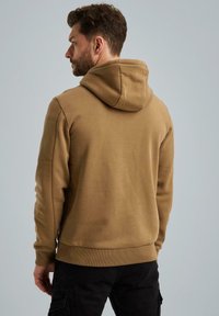Brown hooded sweatshirt with a textured finish. Features ribbed cuffs and hem, and a relaxed fit. Background is a light gray.